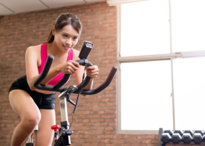 Kobieta trenuje na rowerze z użyciem czujnika stacjonarnego Garmin