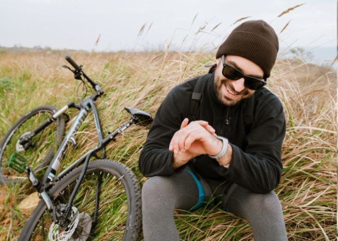 Mężczyzna podczas wycieczki rowerowej używa zegarka z GPS na rower